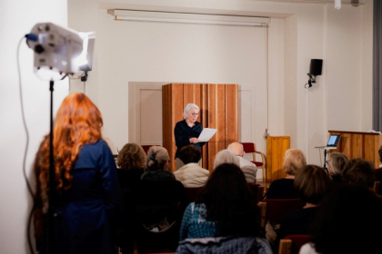 Die Gastgeberin Friederike Heimann eröffnet den Abend im Betsaal der Reformgemeinde, dem Betty-Heine-Saal 